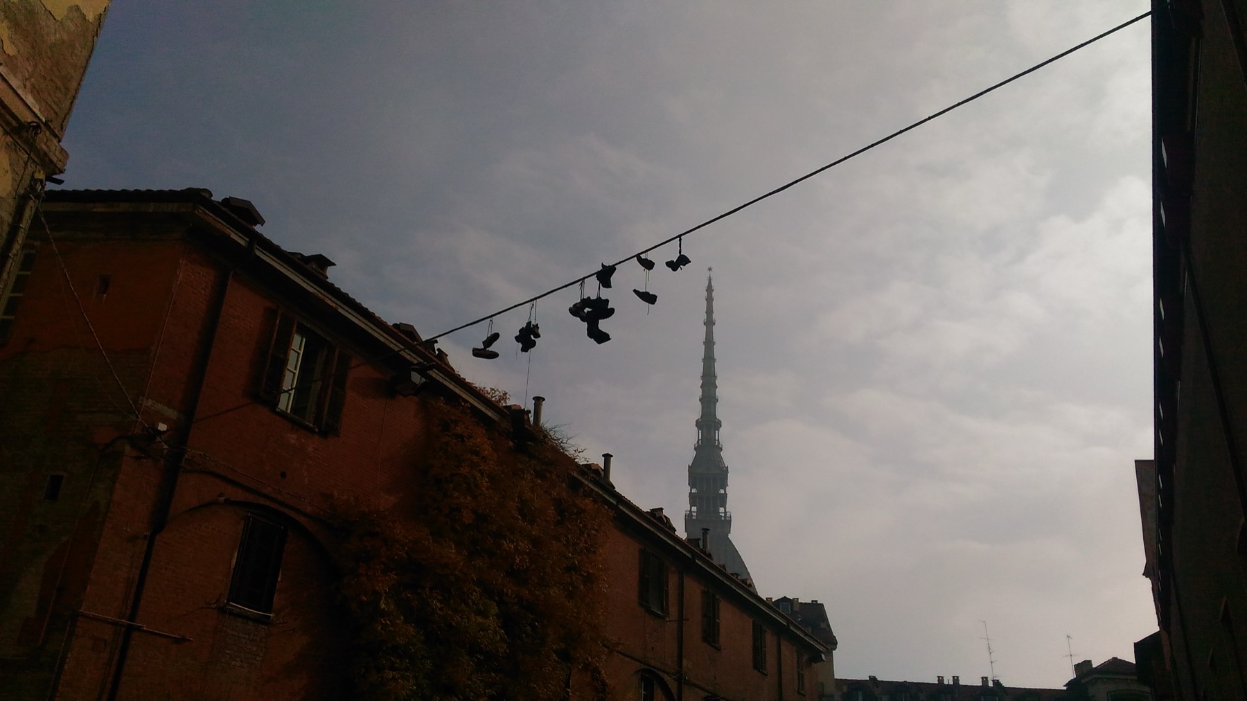 A lived-in Torino street with the Mole Antonelliana beyond it